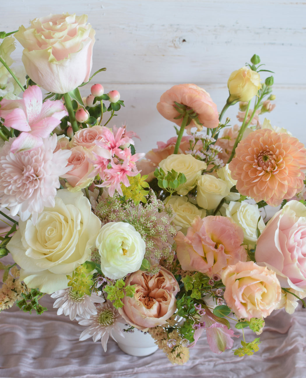 Close up view of the vibrant pink white and peach center and delicate rose petals in the Free Spirit floral design.