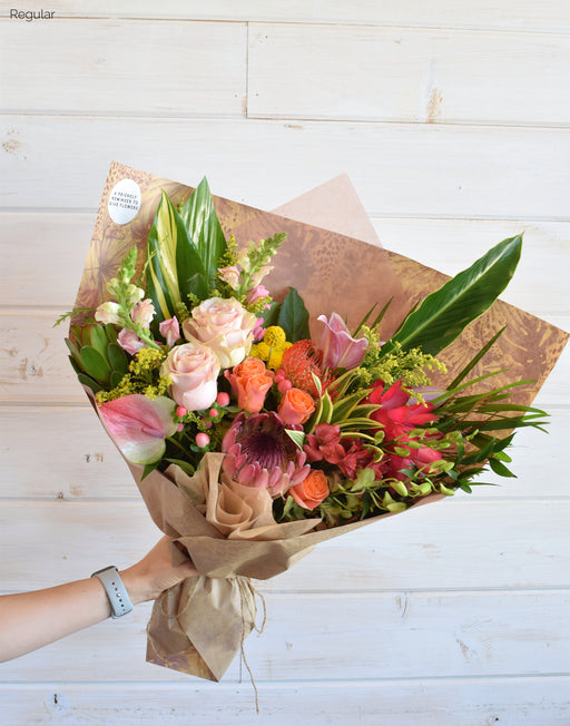 Our regular sized Tropical blooms wrapped in Kraft paper with raffia, offering warm island vibe from Flowerful.