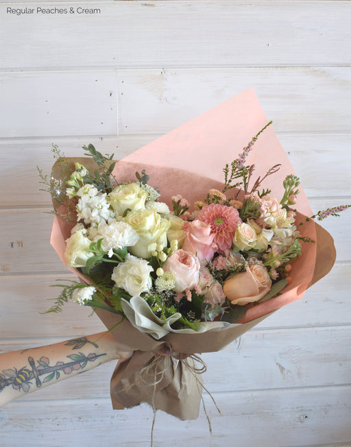 A vibrant Peaches & Cream Ombre Wrap by Flowerful featuring a stunning gradient of fresh flowers, including roses, lisianthus, garden roses, and eucalyptus, styled to perfection. Designed in Laguna Woods and available for delivery across South Orange County. Perfect for any celebration or just because!