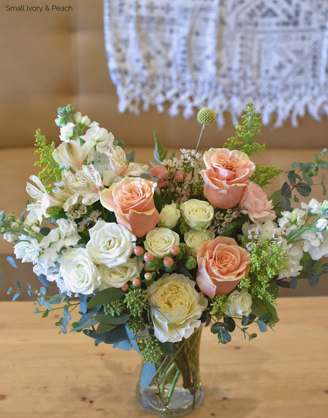 Our small-sized bouquet of flowers in a vase called the Custom Vibe in our ivory and peach colorway.